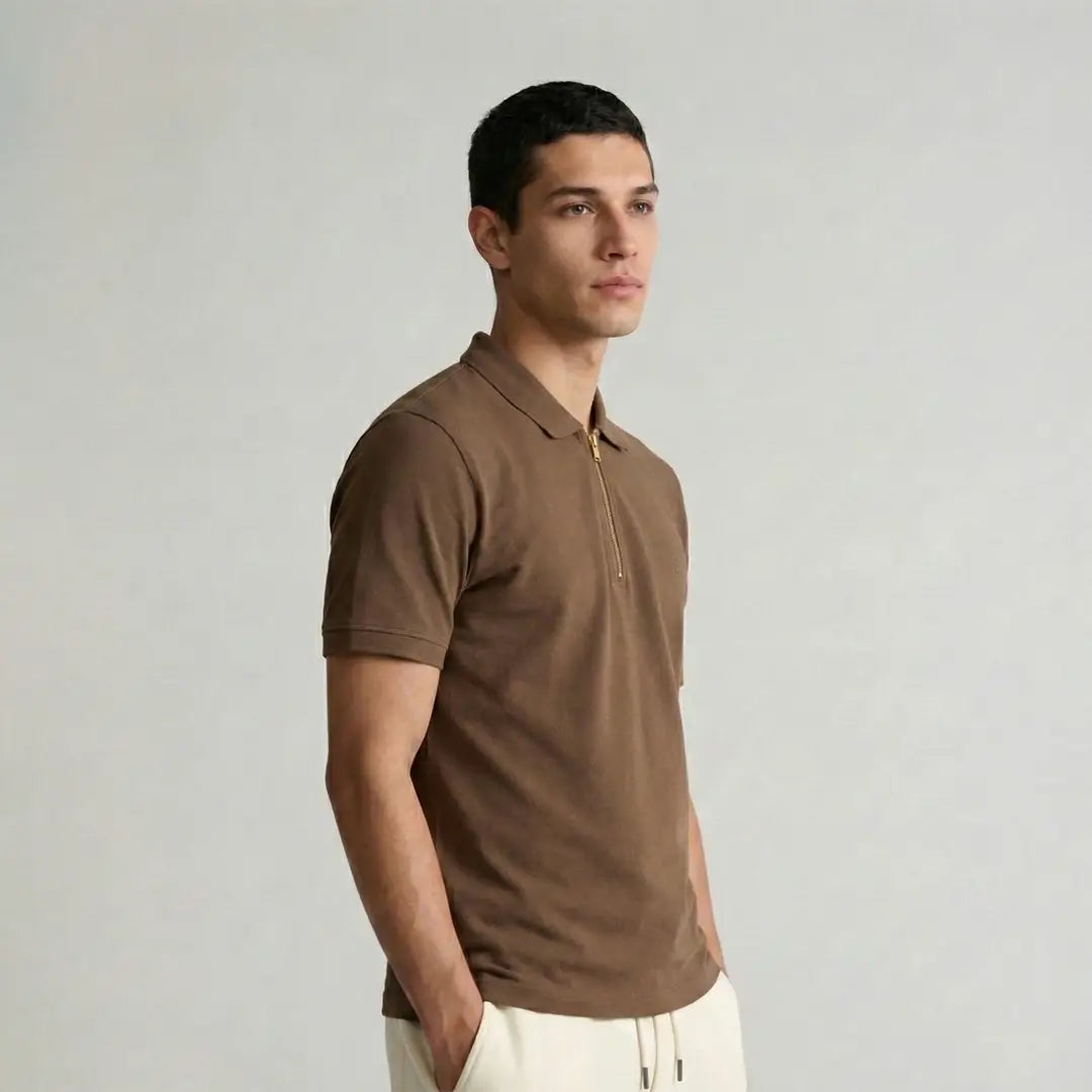 Man wearing a brown polo shirt against a plain background
