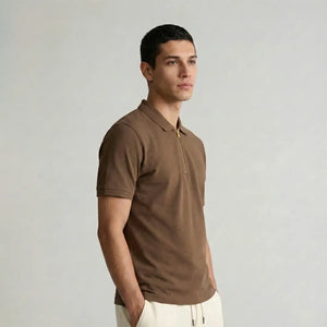 Man wearing a brown polo shirt against a plain background