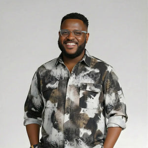 Man wearing a patterned shirt and glasses against a plain background