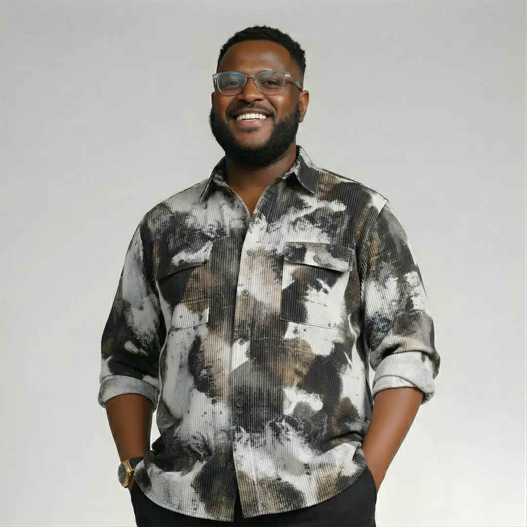 Man wearing a patterned shirt on a plain background