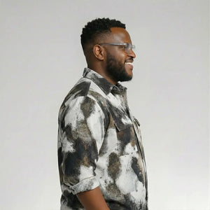 Man wearing a patterned shirt against a plain background