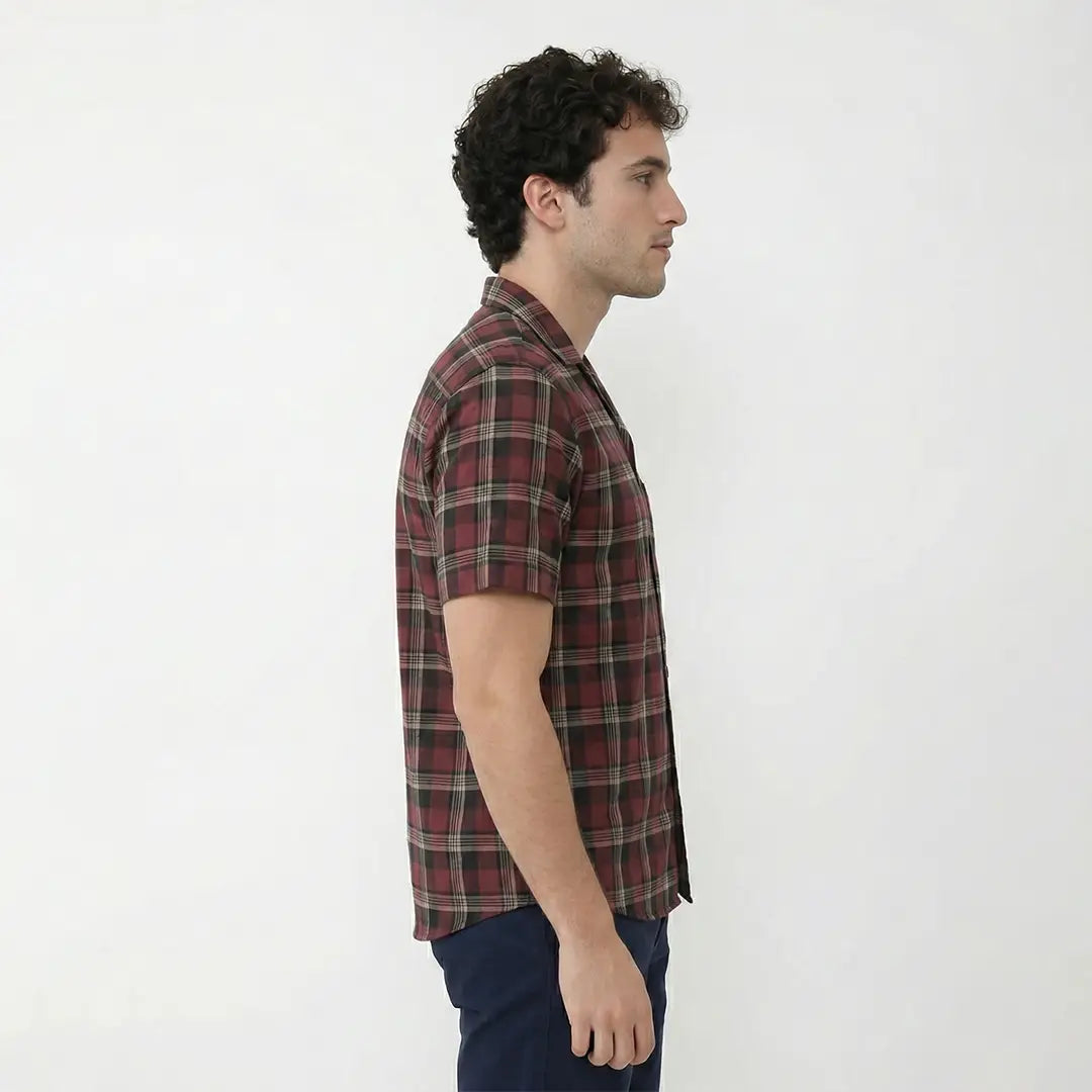 Man wearing a red and black plaid shirt against a white background