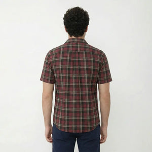 Person wearing a red and green plaid shirt on a white background