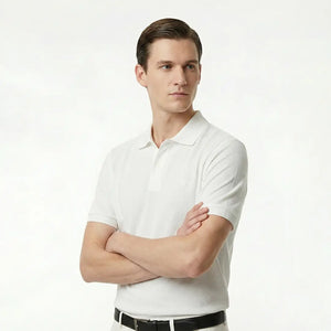 Man wearing a white polo shirt against a plain background