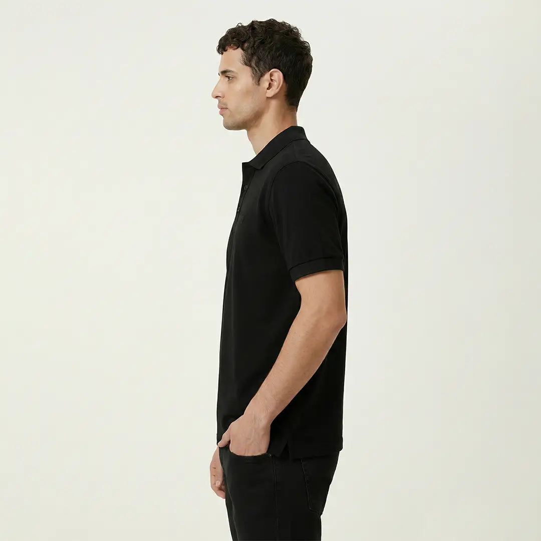 Man wearing a black polo shirt against a plain background