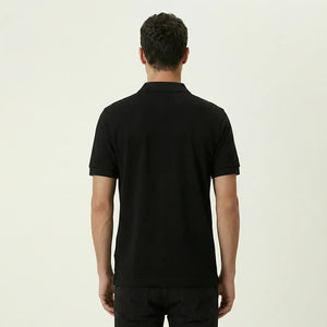 Man wearing a black polo shirt on a plain background