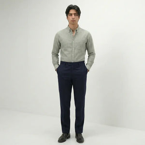 Man wearing a striped shirt and dark pants on a white background