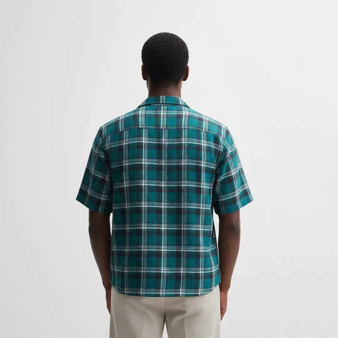 Person wearing a green plaid shirt on a white background