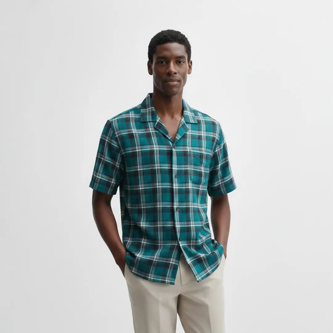 Man wearing a green plaid shirt against a white background