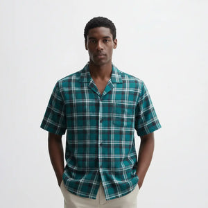 Man wearing a green plaid shirt against a white background