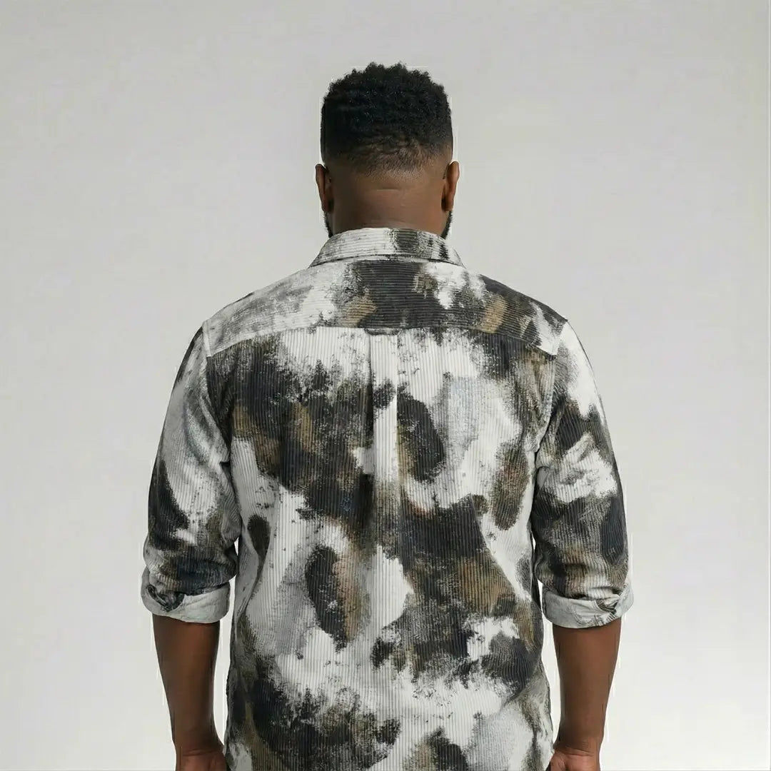 Person wearing a camouflage-patterned shirt against a plain background