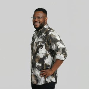 Man wearing a patterned shirt on a plain background