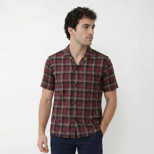 Man wearing a plaid shirt against a white background
