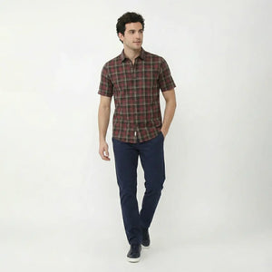 Man wearing a plaid shirt and navy pants on a white background