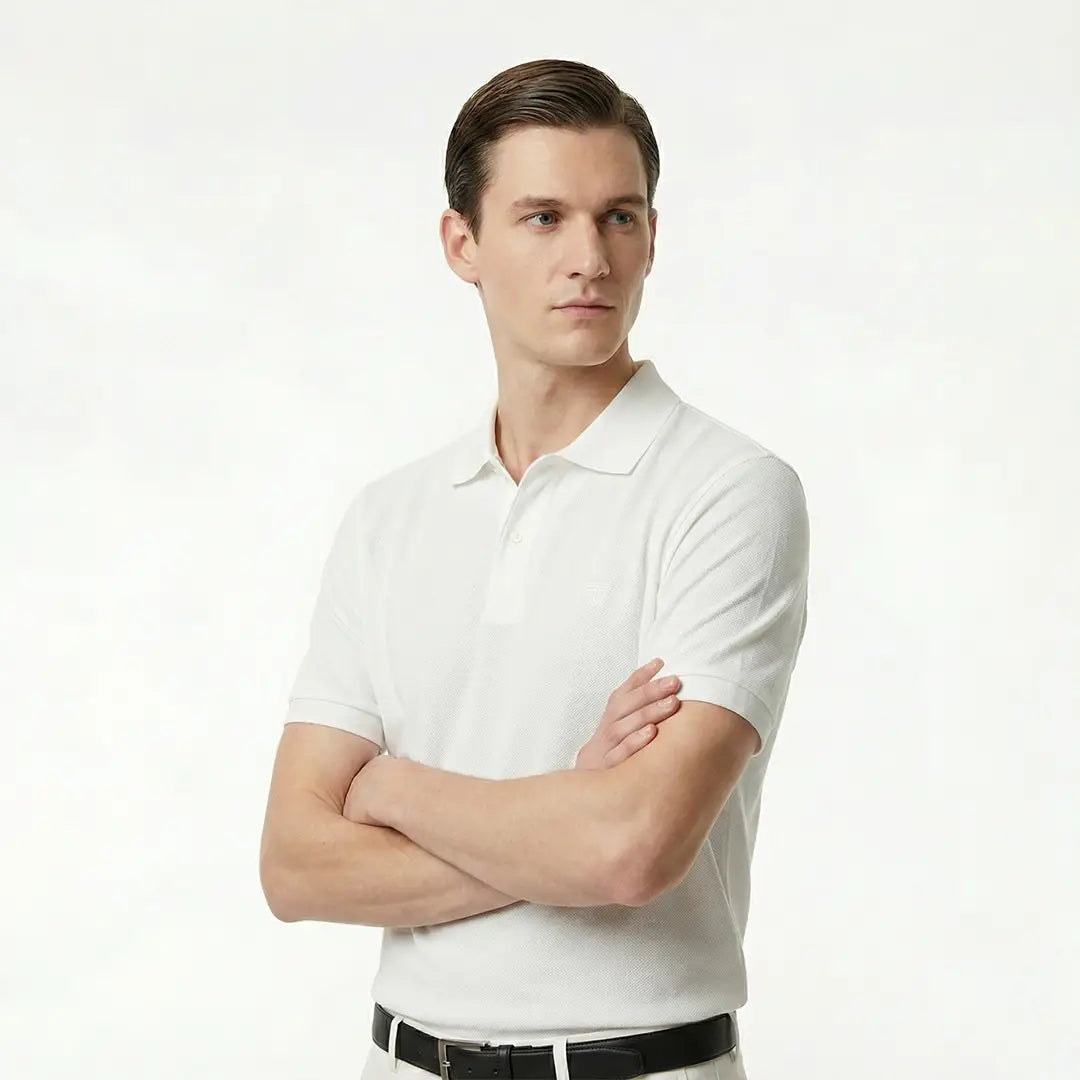 Man wearing a white polo shirt against a plain background