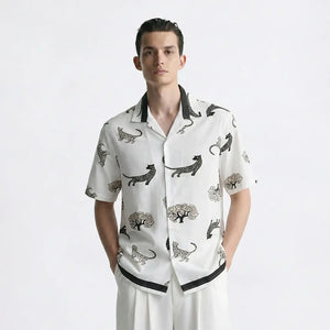 Man wearing a white shirt with black animal patterns on a white background