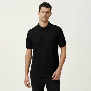 Man wearing a black polo shirt against a plain background