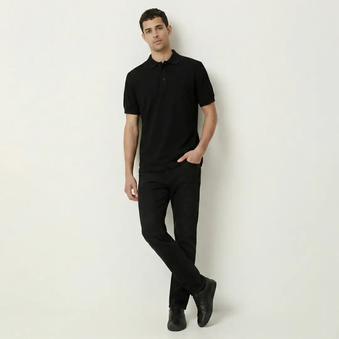 Man wearing a black polo shirt and pants against a white background