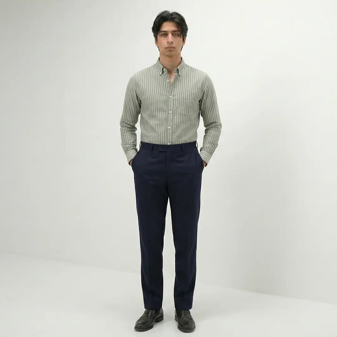 Man wearing a striped shirt and dark pants on a white background